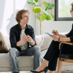 Sesión de terapia cognitivo conductual entre psicólogo y paciente en consulta.