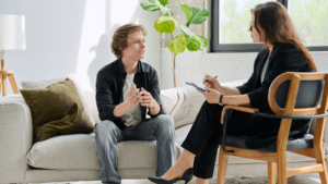 Sesión de terapia cognitivo conductual entre psicólogo y paciente en consulta.