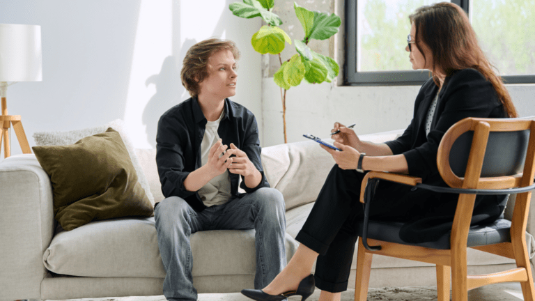 Sesión de terapia cognitivo conductual entre psicólogo y paciente en consulta.