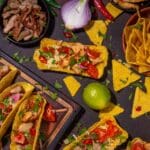 Diferencia comida mexicana y Tex-Mex con tacos, burritos y nachos en mesa rústica