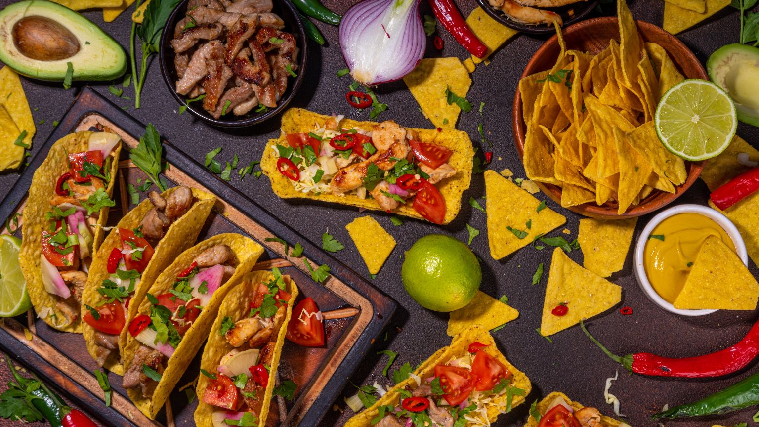 Diferencia comida mexicana y Tex-Mex con tacos, burritos y nachos en mesa rústica